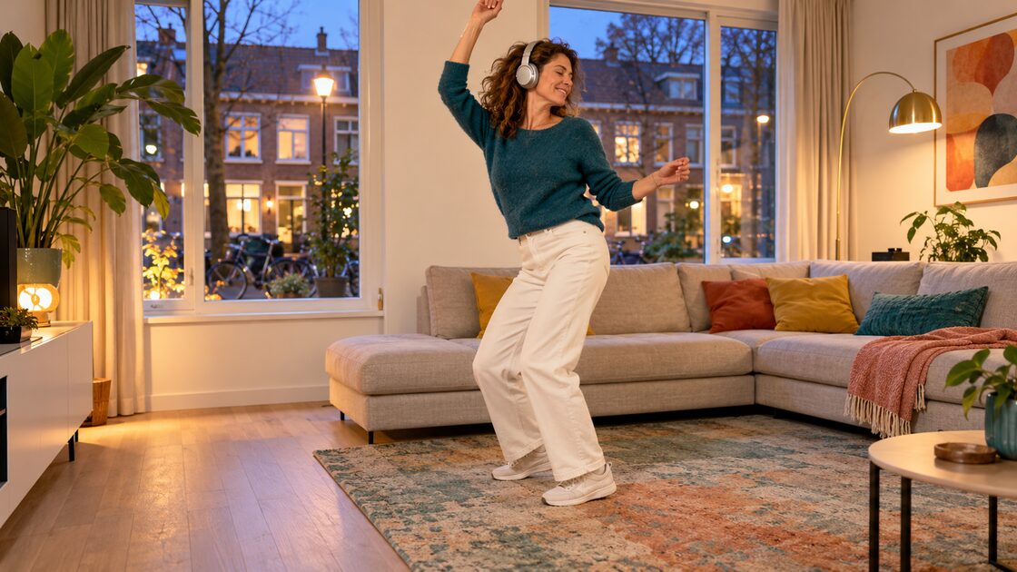 Iemand staat 's avonds op van de bank in een lichte woonkamer